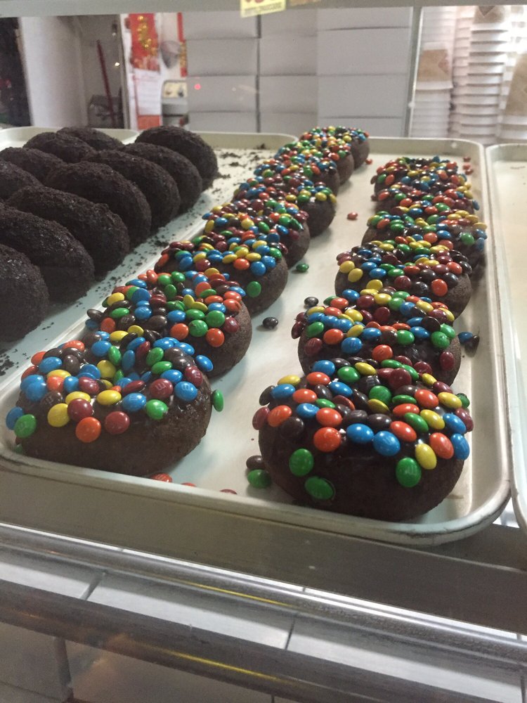 A tray of chocolate donuts covered in candy pieces
