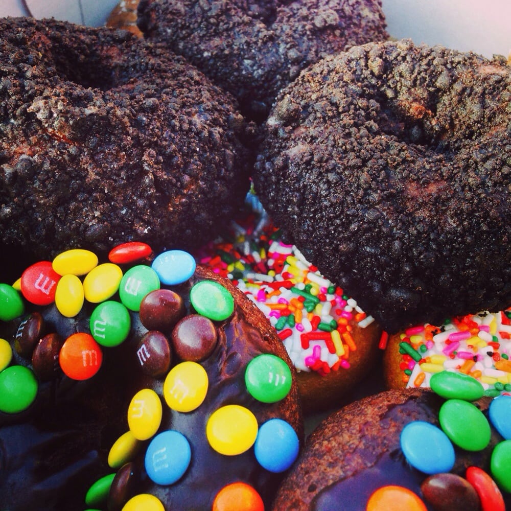 Chocolate donuts topped with candy pieces and sprinkles