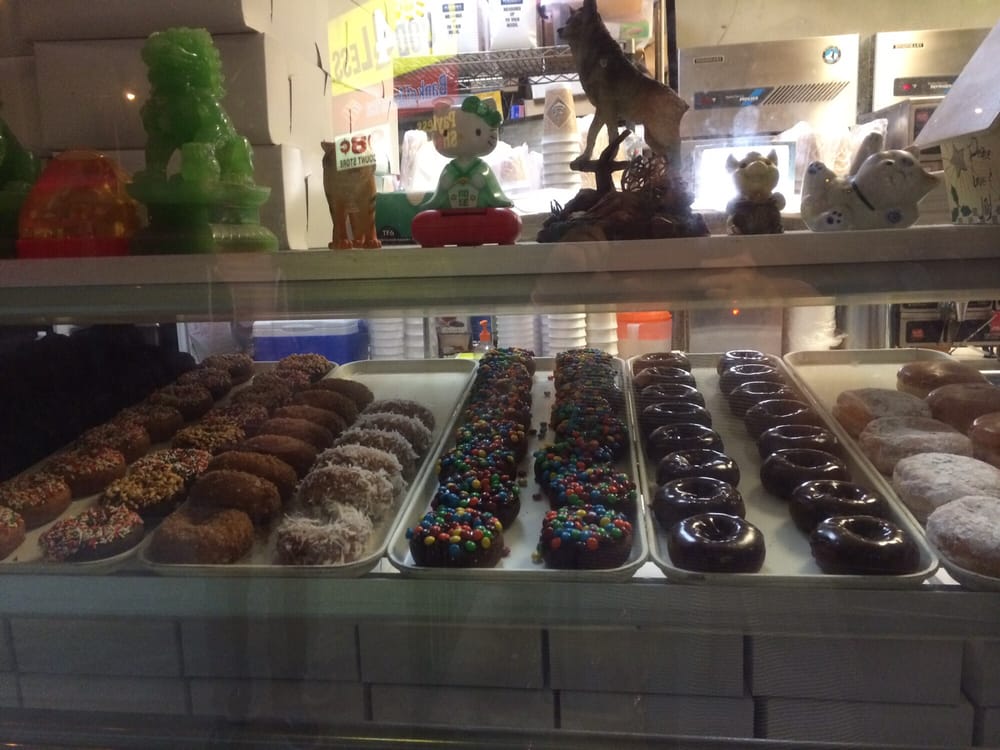 Display case of glazed, chocolate and sprinkled donuts