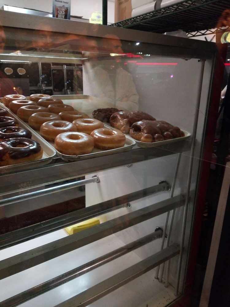 Rack of fresh donuts behind the counter