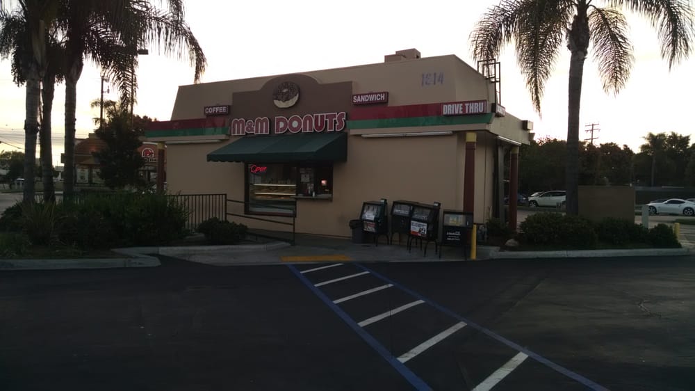 M & M Donuts' shop and parking lot on Katella Avenue at dusk